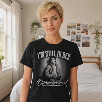 Funny developer t-shirt reading "I'm still in dev, overwhelmed," anxious young monochrome developer on black tee